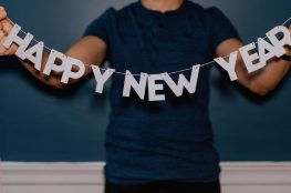 Happy New Year Buchstaben auf einen Faden aufgezogen, gehalten von einer Person