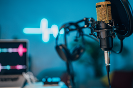 Podcast Mikrofon Gold. Blauer Hintergrund
