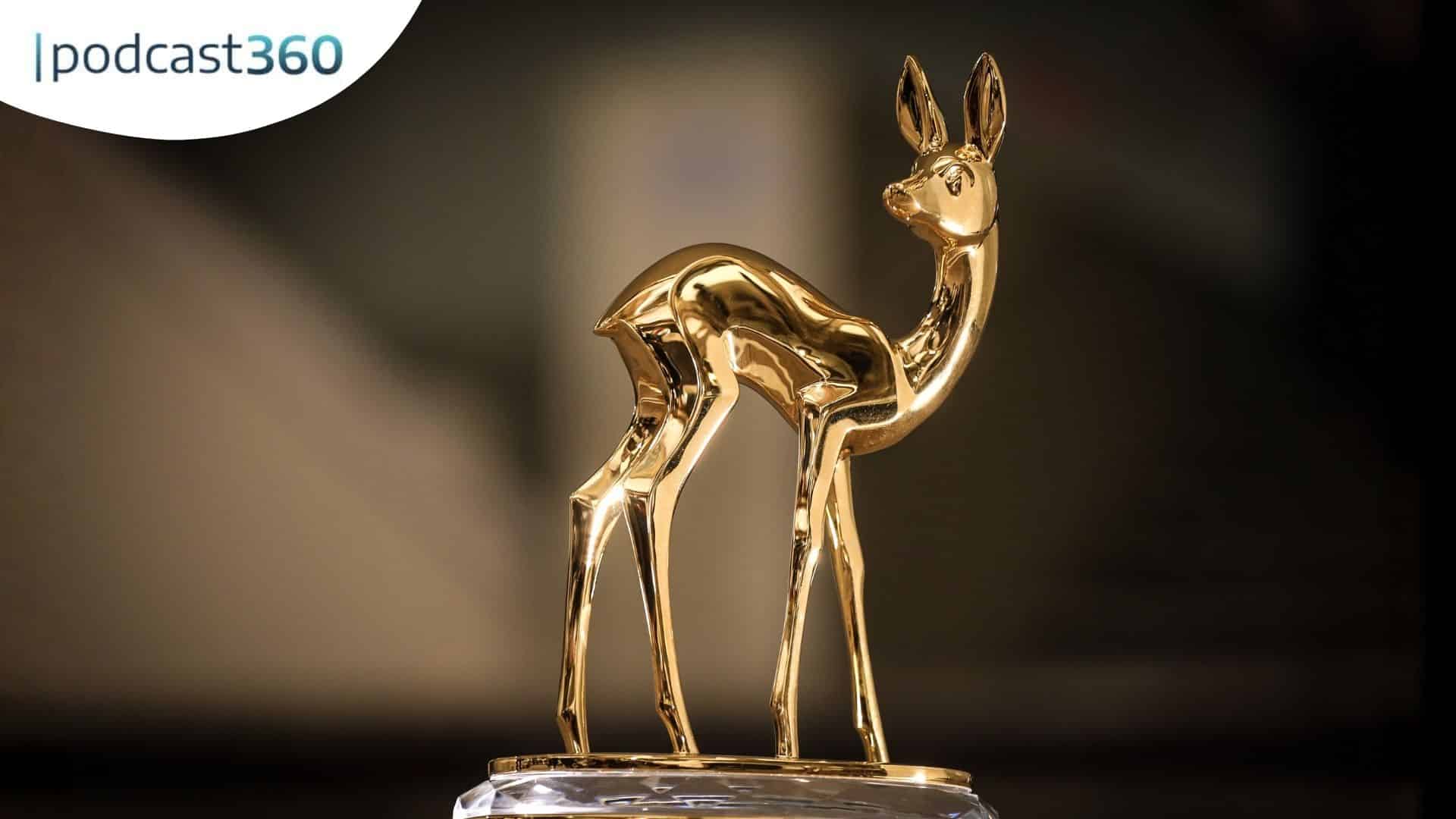 Eine goldene hirschförmige Trophäe auf einem Marmorsockel mit "podcast360"-Logo in der Ecke.