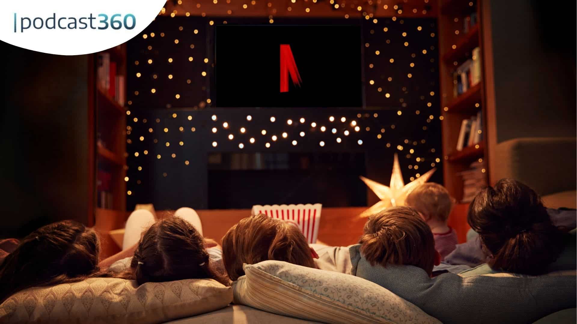Eine Familie schaut gemeinsam Netflix in einem gemütlichen, gedämpft beleuchteten Wohnzimmer mit Lichterketten und Popcorn.