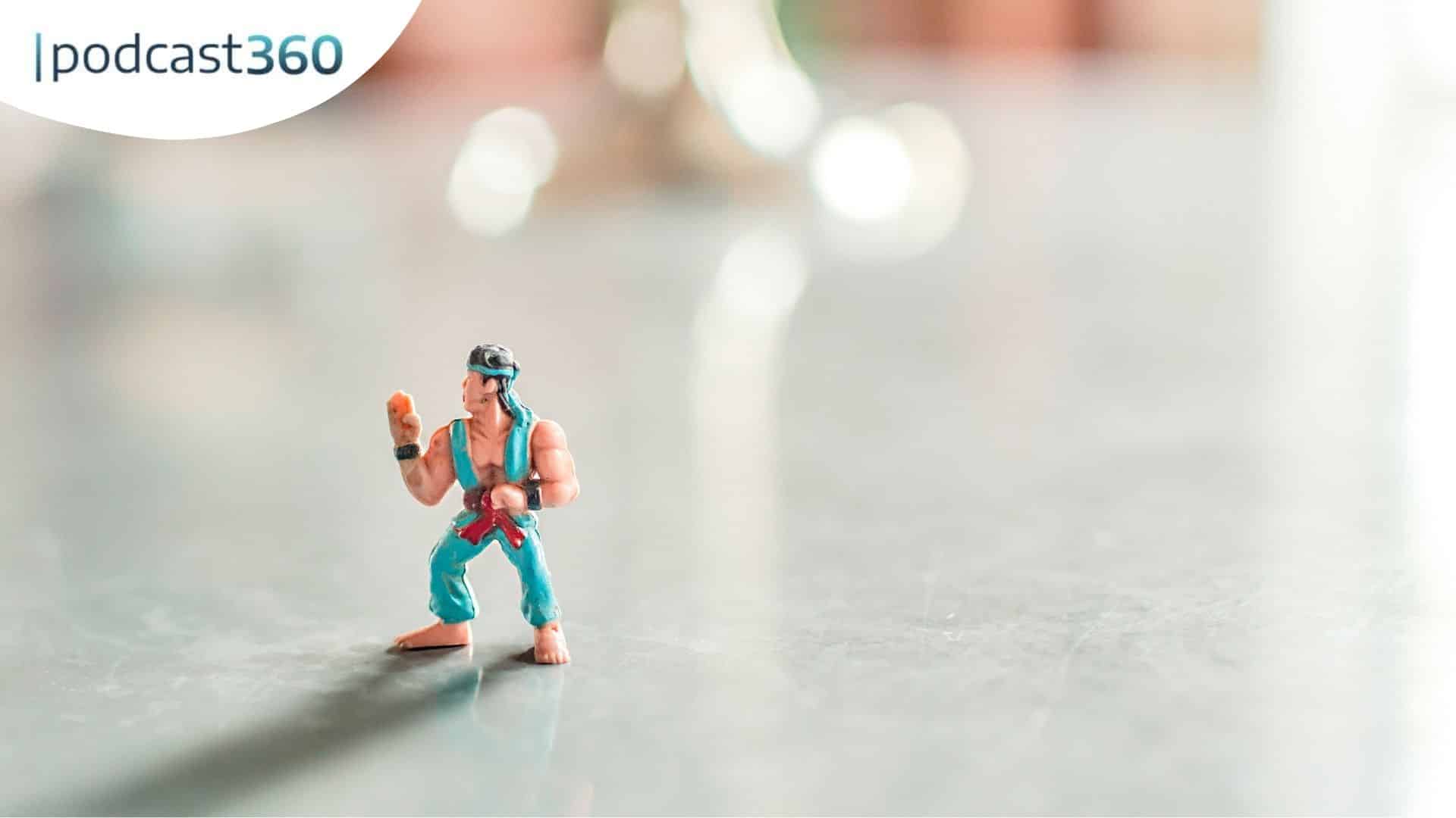 Eine kleine blaue Action-Figur steht auf einer glänzenden Fläche mit dem