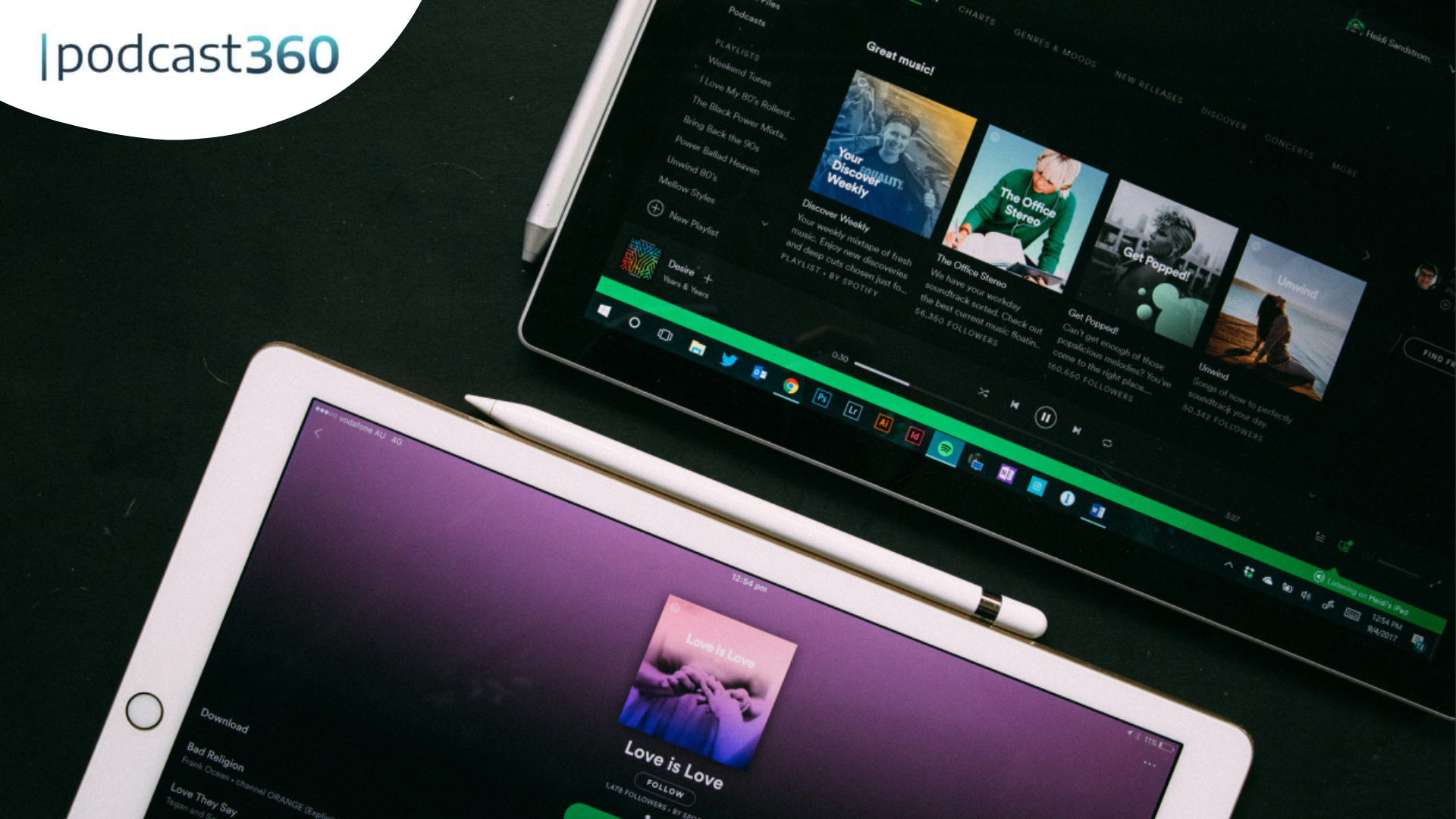 Zwei Tablets auf einem Schreibtisch zeigen verschiedene Musik-Apps wie Spotify an; das